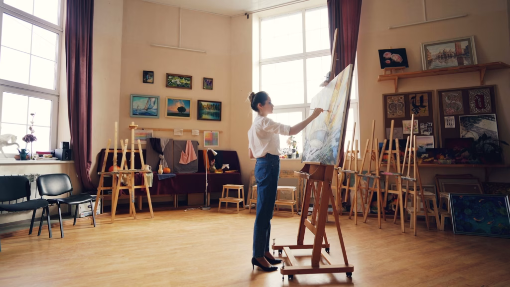 Artist working on a painting in a studio.
